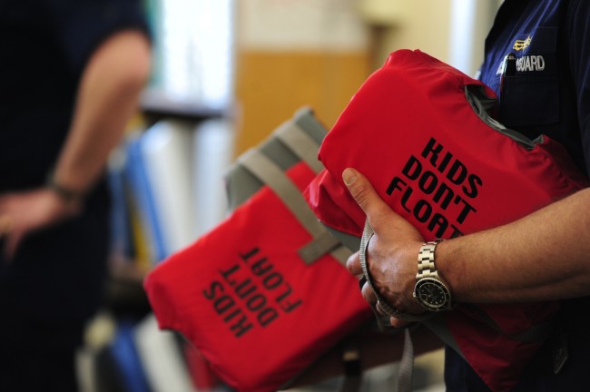 Lt. Tom Pauser, with the 17th Coast Guard District’s prevention division, displays two life jackets while discussing their proper use with students at Hogarth Kingeekuk Sr. Memorial School April 10, 2012. The Coast Guard partnered with Alaska’s Office of Boating Safety to educate students in rural villages about cold-water safety. U.S. Coast Guard photo by Petty Officer 3rd Class Grant DeVuyst.